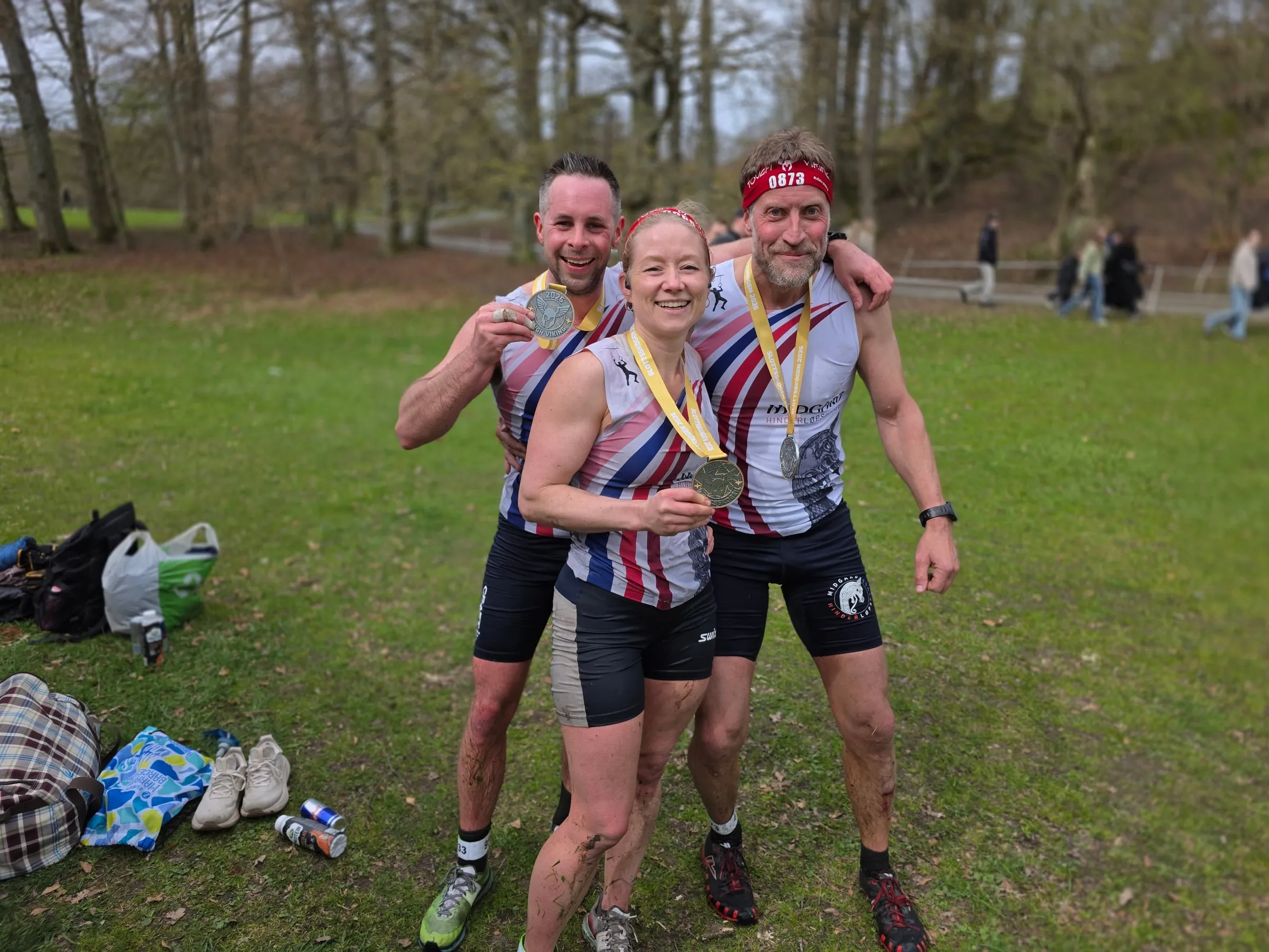 Tre Midgard-løpere i teamvest med medaljer rundt halsen etter Tough Viking